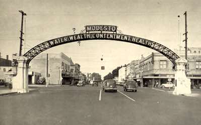 Most notable in this photo is the replacement of the Modesto Bank building and clock tower with a new building in the background on the right side. This building housed Crocker Bank for many years and was demolished to make way for the Gallo Center.
