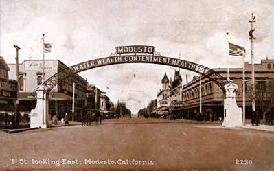 This photo is early enough to show a horse-drawn wagon passing under the arch. The flagpoles, long gone from the two pillars, were added back during the centennial restoration in 2012.